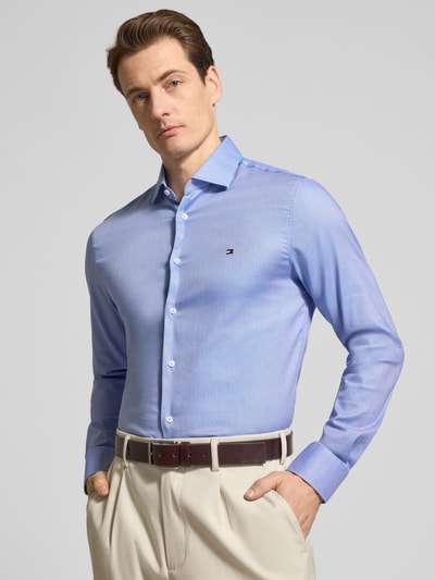 Männermodel trägt Slim Fit Freizeithemd aus Baumwoll-Mix von Tommy Hilfiger, Melange-Optik, Kentkragen, Logo-Detail, Nahaufnahme Oberkörper.