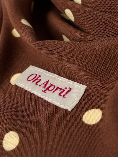 Produktfoto, Schal aus reiner Viskose Modell 'Nevi' von OH APRIL, braune Grundfarbe mit gelben Punkten, Logo-Patch sichtbar, strukturierte Oberfläche, Damen Schal, Dreiecksform, Maße 25 cm Breite und 119 cm Länge