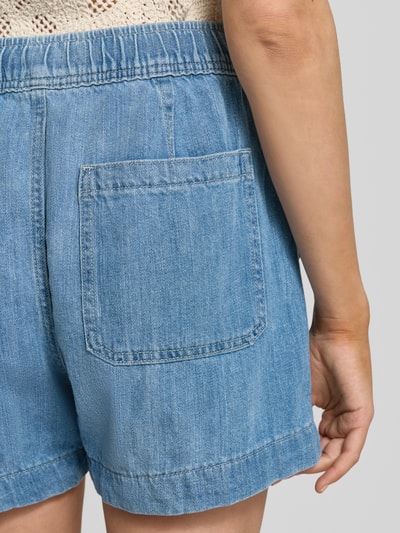 Frauenmodel trägt Straight Fit Shorts in Denim-Optik von GAP aus reiner Baumwolle mit Gesäßtasche, Nahaufnahme Rückansicht.