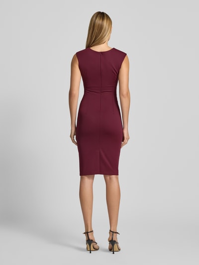 Frauenmodel trägt Cocktailkleid mit Raffungen von Rinascimento in Bordeaux, taillierte Passform, glatte Textur, Ganzkörperansicht Rückansicht. Damen Cocktailkleid von Rinascimento, Material-Mix mit Stretch-Anteil, Rundhalsausschnitt, ärmelloses Design, knielang, rückseitiger Reißverschluss, Rückenlänge Größe S: 96 cm, Brustweite Größe S: 36 cm.