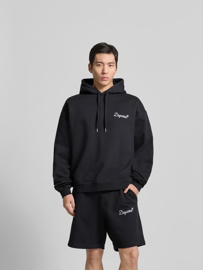Männermodel trägt Regular Fit Hoodie mit Logo-Stitching von Dsquared2 aus schwarzer Baumwolle, Kapuze, elastische Abschlüsse, Ganzkörperansicht von vorne.