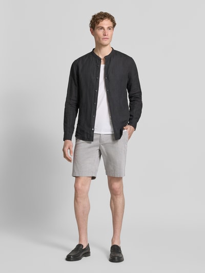 Männermodel trägt Slim Fit Shorts aus Baumwoll-Mix Modell 'SALO' von Marc O'Polo, Optik: Unifarben, Logo-Patch, Ganzkörperansicht von vorne.