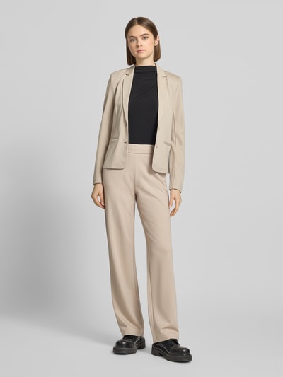 Frauenmodel trägt Straight Fit Hose aus Viskose-Mix Modell 'POPTRASH' von Only in Beige mit seitlichen Eingrifftaschen, Ganzkörperansicht von vorne.