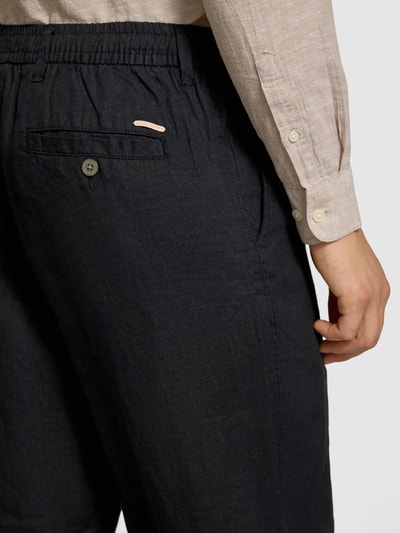 Männermodel trägt zwarte heren linnenbroek met elastische band, regular fit, model 'KARL LAWRENCE' van Jack & Jones, detailopname rug. Binnenbeenlengte maat M 75 cm, bandwijdte maat M 40 cm, zuiver linnen.