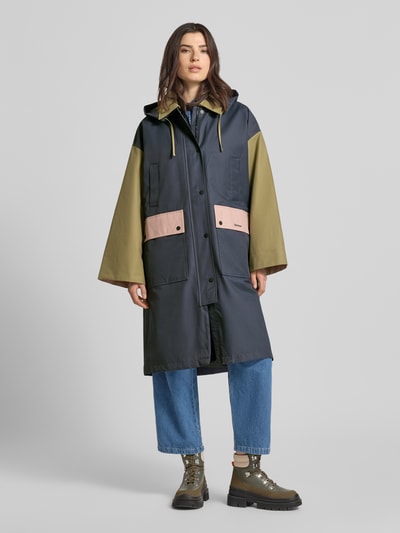 Frauenmodel trägt Regular Fit Funktionsjacke im Color-Blocking-Design Modell 'BLEARIGG' von Barbour in Dunkelblau, Olivgrün und Rosa, Umlegekragen, Kapuze mit Tunnelzug, Zweiwege-Reißverschluss, Druckknopfleiste, Label-Print, Langarm, wasserdicht, Pattentaschen, Baumwoll-Mix, Ganzkörperansicht von vorne.
