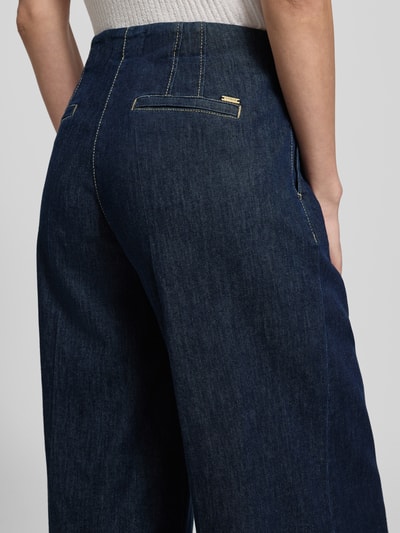 Frauenmodel trägt Wide Fit Jeans mit Lyocell-Anteil Modell 'Jenny' von TONI in Dunkelblau, Baumwoll-Lyocell-Mix, Bundfalten, Eingrifftaschen, Gesäßtaschen, Nahaufnahme Rückansicht.