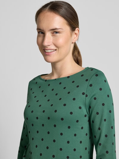 Frauenmodel trägt Shirt aus reiner Baumwolle mit 3/4-Arm von Christian Berg Woman in Grün mit schwarzen Punkten, taillierte Passform, Nahaufnahme Oberkörper.