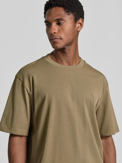 Męski model ma na sobie Oversized T-Shirt aus reiner Baumwolle od Lindbergh, kolor beżowy, krój oversized, półrękaw, bawełna, Długość tyłu w rozmiarze M: 70 cm, z przodu zbliżenie na górną część ciała.