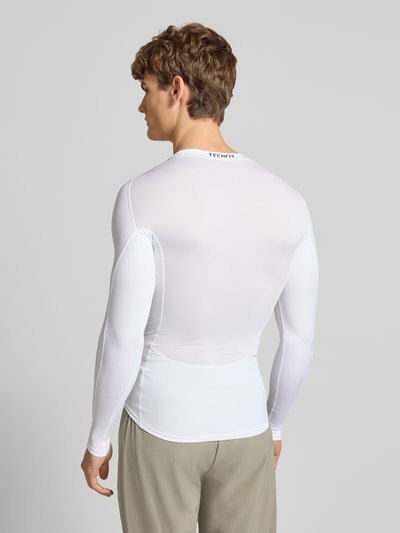 Männermodel trägt Longsleeve mit Label-Print von adidas Training in Weiß, Slim Fit, Material-Mix mit Stretch, Ganzkörperansicht Rückansicht