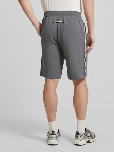Männermodel trägt graue Shorts mit elastischem Bund von EA7 Emporio Armani, Baumwoll-Mix, Regular Fit, Ganzkörperansicht Rückansicht.