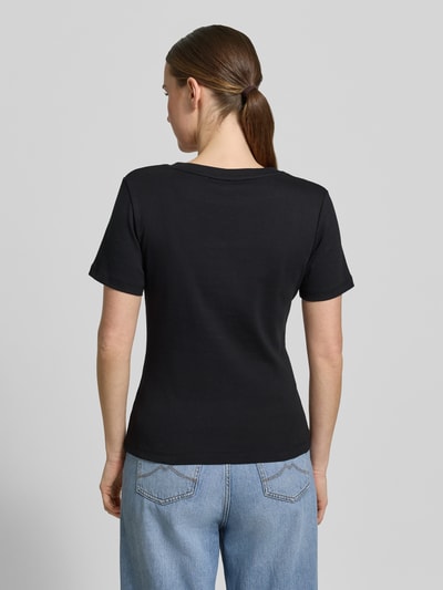 Frauenmodel trägt Slim Fit T-Shirt aus reiner Baumwolle von Tommy Hilfiger, Optik: Unifarben, Passform: Slim-Fit, Logo-Stitching, V-Ausschnitt, Ärmelform: Kurzarm, Materialverarbeitung: Jersey, reine Baumwolle, Ganzkörperansicht Rückansicht.
