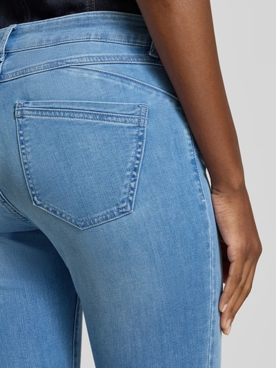 Kobiece model nosi Slim Fit Jeans aus Baumwoll-Mix Modell 'SHAKIRA' od Brax, stylizowana na denim, krój slim fit, średni stan, naszywka z logo, szlufki na pasek, zapięcie na guzik i ukryty zamek błyskawiczny, materiał: mieszanka bawełny, detal: tekstura gładka, jasnoniebieski kolor, detailaufnahme tył.