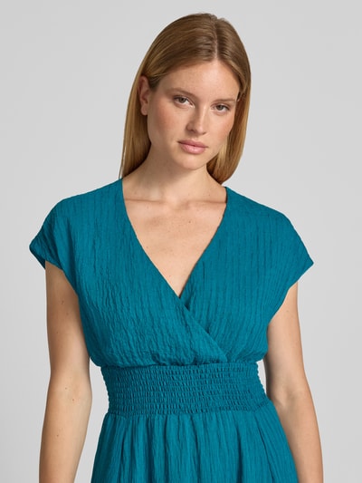 Frauenmodel trägt Midikleid aus Viskose-Mix mit Smok-Details von zero, taillierter Schnitt, Strukturmuster, Nahaufnahme Oberkörper.