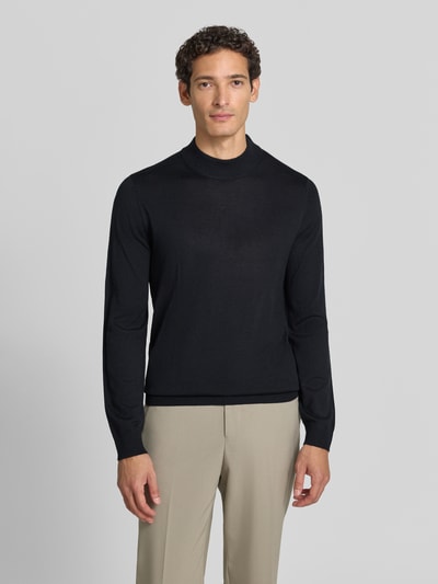 Männermodel trägt Regular Fit Turtleneck aus Woll-Mix von Christian Berg Men in Schwarz, glatte Textur, gerippte Abschlüsse, Ganzkörperansicht von vorne. Rückenlänge bei Größe M: 69 cm, Ärmellänge bei Größe M: 51 cm.