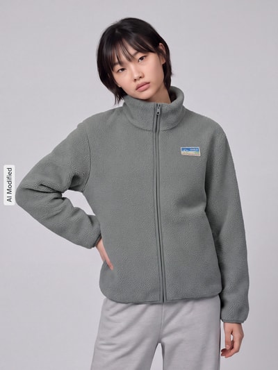 Modelka nosi kurtkę z polaru Regular Fit Fleecejacke mit Reißverschluss model 'EVA' od ONLY w kolorze szarym, tekstura miękka, Ganzkörperansicht von vorne, KI-modifiziertes Bild.