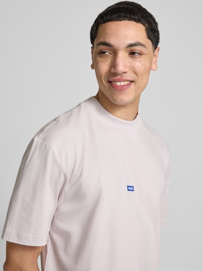 Männermodel trägt Regular Fit T-Shirt aus reiner Baumwolle Modell 'Niereos' von HUGO in Optik: Unifarben mit Label-Patch, Nahaufnahme Oberkörper.