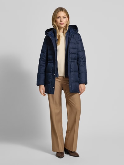 Vrouwenmodel draagt Daunenmantel mit Kapuze van Lauren Ralph Lauren in donkerblauw, taillering, met capuchon en steekzakken. Volledige lichaamsaanzicht van voren.