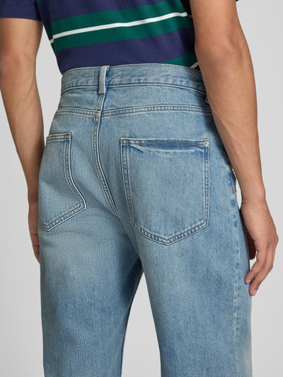 Männermodel trägt Baggy Fit Jeans mit Knopfverschluss von REVIEW, helle Waschung, reine Baumwolle, 5-Pocket-Design, Ganzkörperansicht Rückansicht.