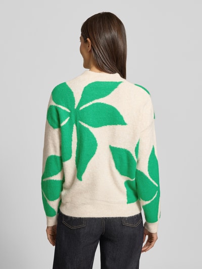 Frauenmodel trägt Oversized Strickpullover mit gerippten Abschlüssen Modell 'OMEA' von B.Young, beige mit grünen Blattformen, Material-Mix mit Woll-Anteil, Ganzkörperansicht Rückansicht.