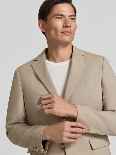 Männermodel trägt Regular Fit Sakko mit Viskose-Mix Modell 'Charles' von Matinique in Beige, glatte Textur, Nahaufnahme Oberkörper.