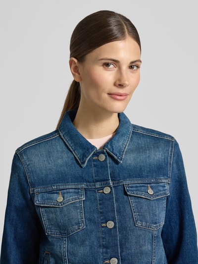 Vrouwenmodel draagt Regular Fit Jeansjacke aus Baumwoll-Mix van Marc O’Polo in denim optiek met knoopsluiting, borstzakken en label patch, Nahaufnahme bovenlichaam.