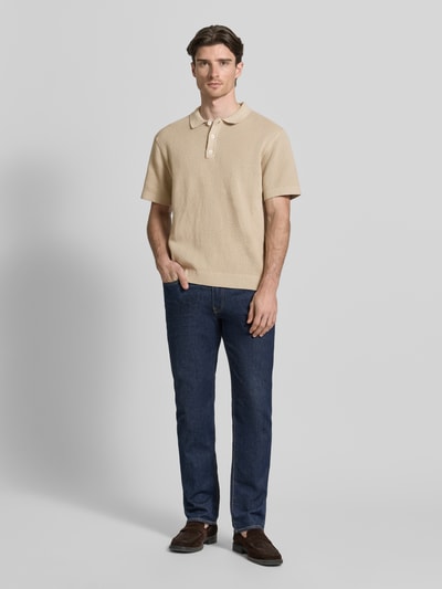 Männermodel trägt Regular Fit Poloshirt mit Label-Detail Modell 'ISAKSSON' von Casual Friday aus Reine Baumwolle, Ganzkörperansicht von vorne. Rückenlänge bei Größe M: 67 cm, Polokragen, Halbarm, Beige-Farbton, glatte Textur.