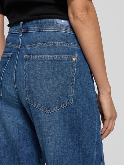 Vrouwenmodel draagt blauwe Jeans met wijd been, model 'MORGAN' van Brax, katoen-elastaanmix, detailopname heup en achterzak.