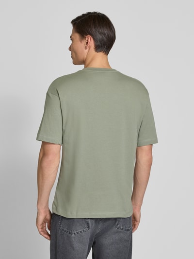 Männermodel trägt Regular Fit T-Shirt mit Label-Schriftzug aus reiner Baumwolle von Tommy Hilfiger, Optik: Unifarben, Ganzkörperansicht Rückansicht.