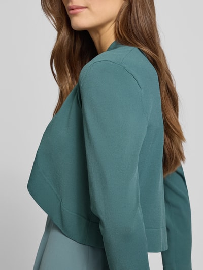 Vrouwenmodel draagt Bolero mit gerippten Abschlüssen van Jake*s Cocktail in viscosemix, losse pasvorm, geribde boorden, 3/4-mouwen, zijaanzicht bovenlichaam.