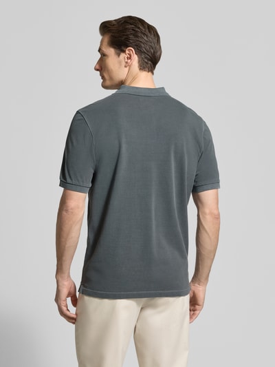 Männermodel trägt Regular Fit Poloshirt aus reiner Baumwolle von Marc O'Polo in Optik: Unifarben, Materialverarbeitung: Piqué, Ganzkörperansicht Rückansicht.