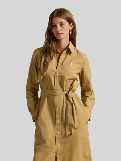 Frauenmodel trägt Hemdblusenkleid aus Baumwoll-Leinen-Mix von Polo Ralph Lauren, taillierter Schnitt, Hemdblusenkragen, Knopfleiste, Label-Stitching, Taillengürtel, Farbe Beige, glatte Textur, Nahaufnahme Oberkörper.