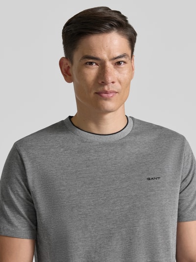 Männermodel trägt T-Shirt mit Rundhalsausschnitt und Label-Stitching von Gant in Grau, Reine Baumwolle, Regular-Fit, Nahaufnahme Oberkörper.