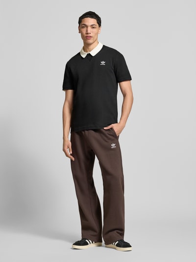 Männermodel trägt Regular Fit T-Shirt mit Baumwoll-Anteil von adidas Originals in Schwarz, Waffelstruktur, Logo-Stitching, Ganzkörperansicht von vorne.
