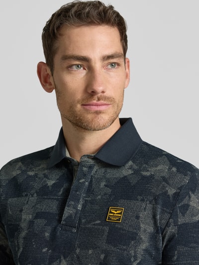 Männermodel trägt Slim Fit Poloshirt mit Label-Patch von PME Legend aus Reine Baumwolle, Allover-Look, Knopfleiste, Nahaufnahme Oberkörper.