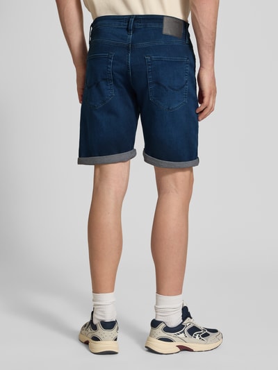Männermodel trägt Jeansshorts mit Umschlag Modell 'RICK' von Jack & Jones aus Baumwoll-Mix mit Woll-Anteil, Regular-Fit, Rückansicht.