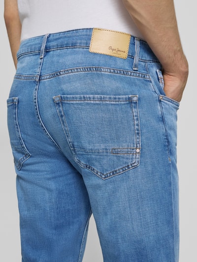 Männermodel trägt Regular Fit Jeans aus Baumwoll-Mix Modell 'CASH' von Pepe Jeans in heller Denim-Optik mit Label-Patch, Nieten, Kontrastnähte, 5-Pocket-Design; Detailaufnahme Rückansicht.