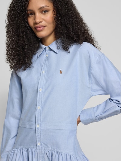 Frauenmodel trägt Tailliertes Blusenkleid aus reiner Baumwolle von Polo Ralph Lauren in Hellblau mit Logo-Detail und Knopfleiste, Nahaufnahme Oberkörper.