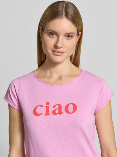 Frauenmodel trägt T-Shirt mit Statement-Print und Rundhalsausschnitt von Christian Berg Woman in Rosa, reine Baumwolle, Nahaufnahme Oberkörper.