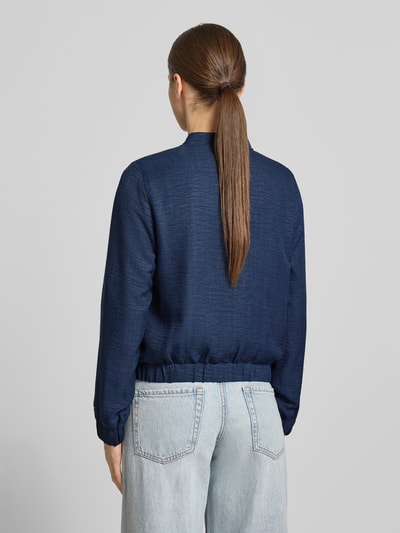 Frauenmodel trägt Regular Fit Blouson mit Baseball-Kragen Modell 'MELANEY' von Vero Moda, melange Optik, Ganzkörperansicht Rückansicht.