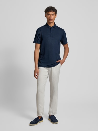 Männermodel trägt Slim Fit Poloshirt aus Leinen-Elasthan-Mix von OLYMP Level Five in Dunkelblau mit Knopfleiste, Ganzkörperansicht von vorne.