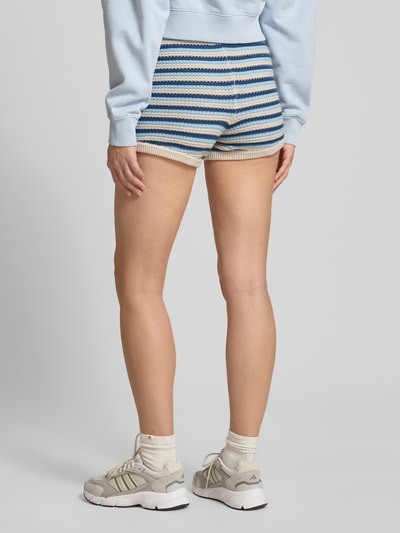 Frauenmodel trägt Shorts in Strick-Optik von Pegador in Blau-Beige mit Label-Patch, Reine Baumwolle, Körpernahe Passform, Ganzkörperansicht Rückansicht.