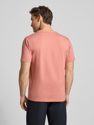 Männermodel trägt Regular Fit T-Shirt aus Baumwoll-Mix Modell 'SANDER' von SELECTED HOMME, rosa Seersucker, Rückansicht Ganzkörperansicht.