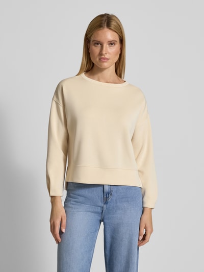 Frauenmodel trägt Relaxed Fit Sweatshirt mit Viskose-Anteil von comma in Beige, U-Boot-Ausschnitt, glatte Textur, Ganzkörperansicht von vorne.