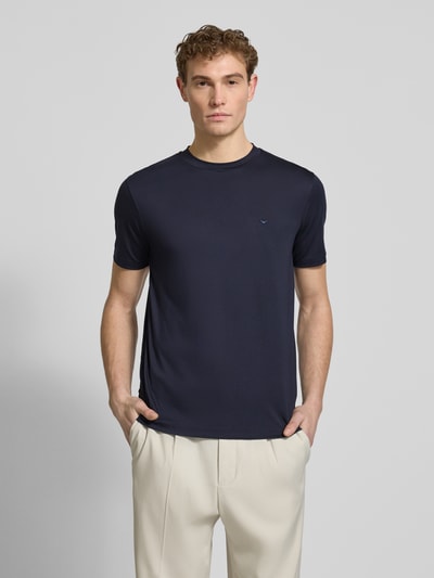 Männermodel trägt Regular Fit T-Shirt mit Rundhalsausschnitt von Emporio Armani in Dunkelblau, glatte Textur, Vorderansicht, Nahaufnahme Oberkörper. Elastischer Modal-Mix mit Belseta-Anteil, kurzärmelige Passform, Rückenlänge bei Größe M 71 cm.