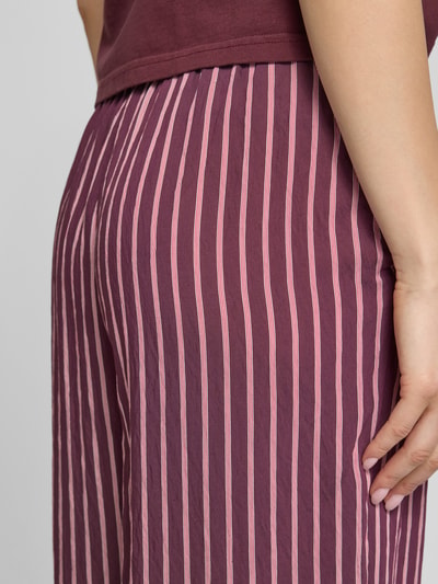 Frauenmodel trägt Regular Fit Weite Hose aus Viskose-Mix Modell 'MELDOLA' von Only, mehrfarbig gestreift, Popeline, Nahaufnahme Hüfte.