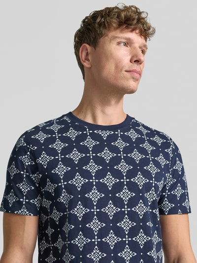 Männermodel trägt Regular Fit T-Shirt aus reiner Baumwolle von s.Oliver RED LABEL, donkerblauw met wit patroon, Nahaufnahme Oberkörper.
