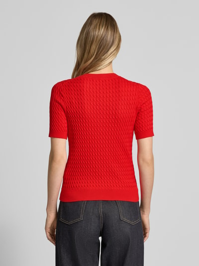 Frauenmodel trägt Slim Fit T-Shirt aus reiner Baumwolle von Tommy Hilfiger in Optik: Unifarben mit Zopfmuster, Logo-Detail, Rundhals, Kurzarm, Strick, reine Baumwolle, Ganzkörperansicht Rückansicht.