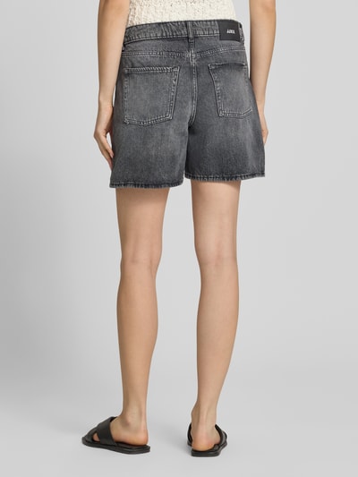 Frauenmodel trägt Shorts in Denim-Optik Modell 'Seville' von JJXX, reine Baumwolle, 5-Pocket-Design in Grau, Ganzkörperansicht Rückansicht.