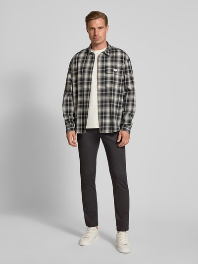 Männermodel trägt Slim Fit Chino aus Baumwoll-Mix von bugatti, dunkle Farbe, Münztasche, Gesäßtaschen, Ganzkörperansicht von vorne.