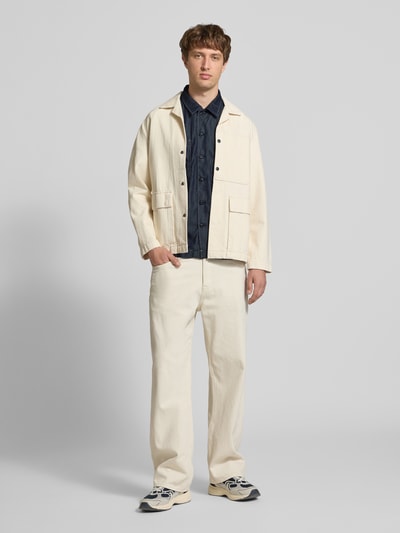 Männermodel trägt Regular Fit Freizeithemd aus Lyocell-Mix Modell 'Bowling' von G-Star Raw in Denim-Optik, kurzärmelig, Brusttaschen, Reverskragen, mit durchgehender Knopfleiste, Rückenlänge bei Größe M 72 cm, Schulterbreite 48 cm, Ärmellänge 30 cm, Ganzkörperansicht von vorne.